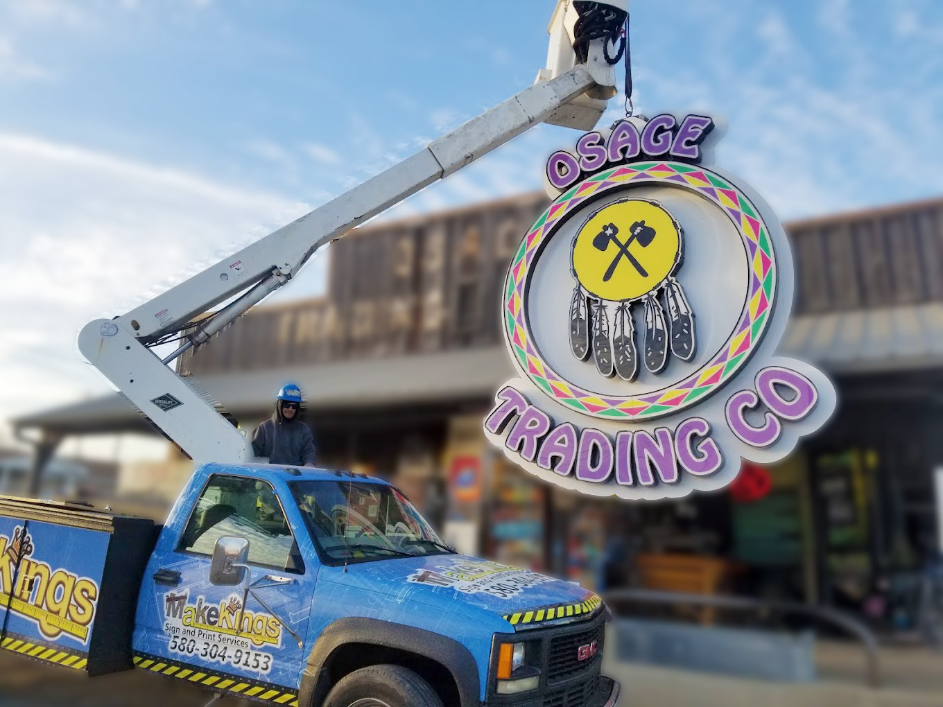 MakeKings crew installing an illuminated Osage Trading Co sign from a bucket truck